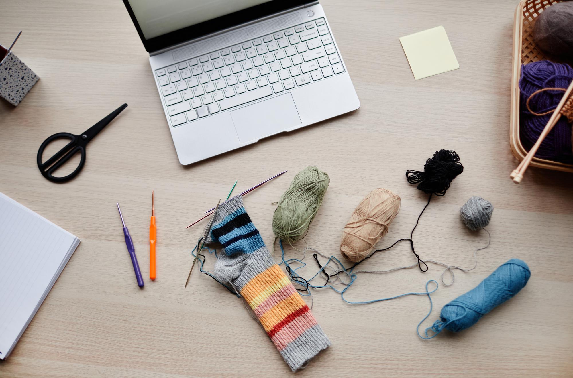 Flatlay of embroidery tools and laptop